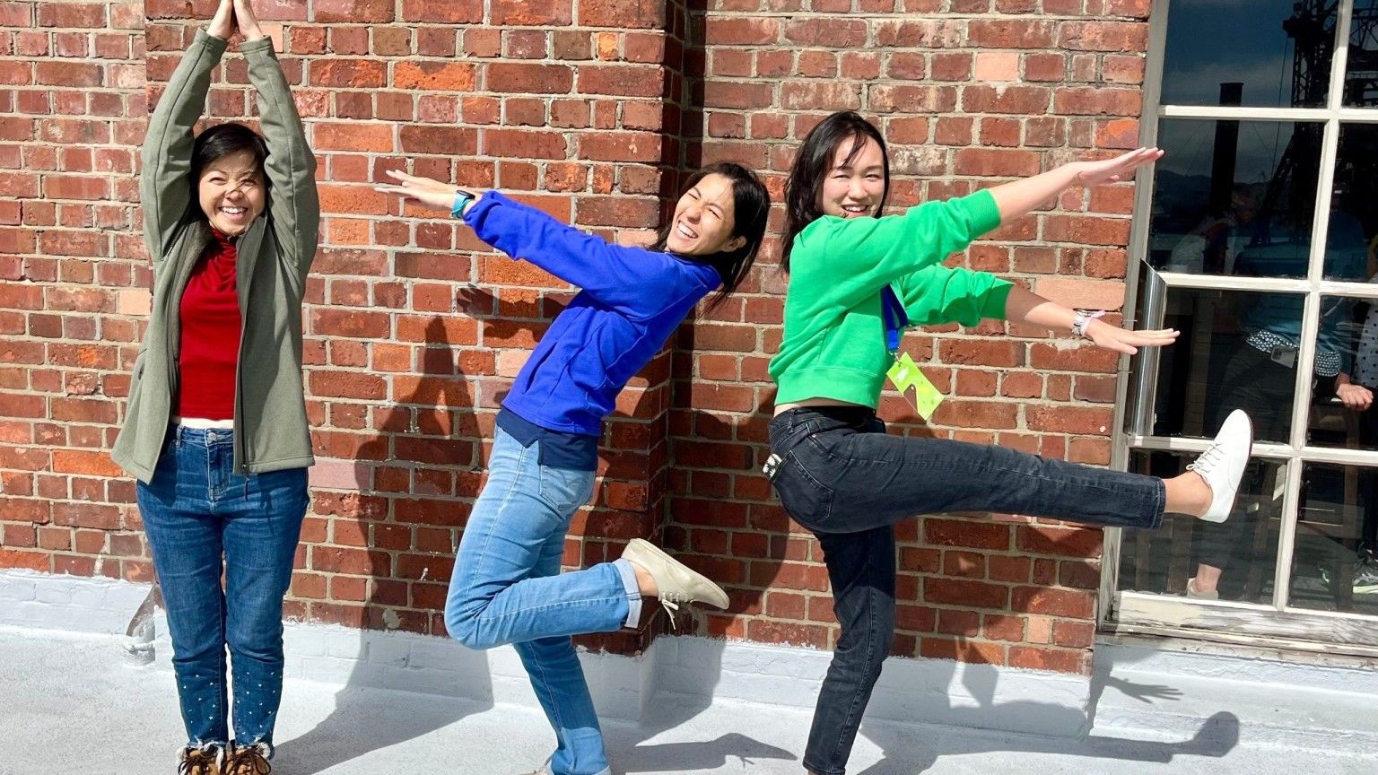 Three women posing playfully at the IZE conference in Wellington, New Zealand, October 2023.
